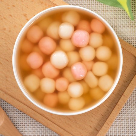 Little red and white tangyuan (tang yuan, glutinous rice dumpling balls) with sweet syrup soup in a bowl for Winter solstice festival food.の写真素材