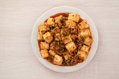 Mapo tofu. Chinese traditional stir-fried tofu with hot spicy sauce on wooden table background.の写真素材