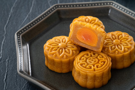 Cantonese moon cake with lotus seed pastry and salted egg yolk for Mid-Autumn Festival on table...