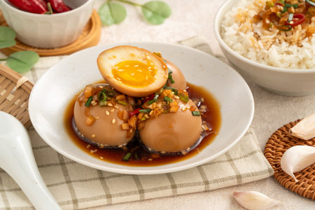 Korean mayak eggs marinated in soy sauce, topped with garlic, chili, onion and scallions, served as...