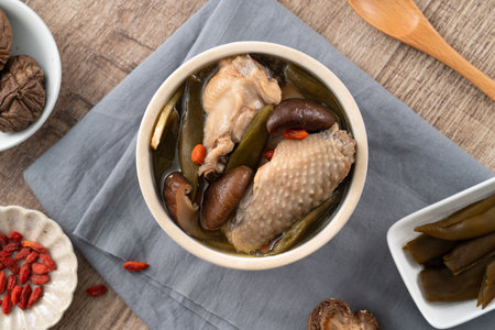 Delicious Taiwanese peeled green chili pepper chicken soup with mushroom and goji berry on table background.の写真素材