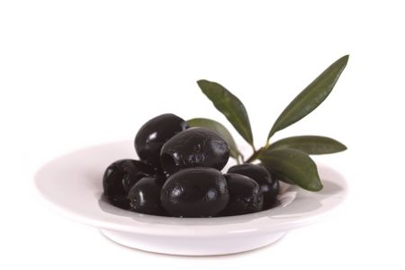 Olives on plate with branch isolated on white backgroundの写真素材