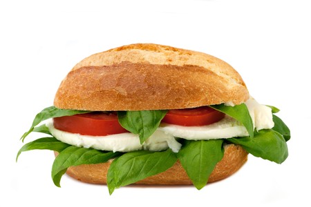 An italian sandwich with fresh buffalo mozzarella, red ripe tomatoes and basil isolated on whiteの写真素材