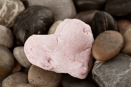Rose quartz heart on pebblesの写真素材