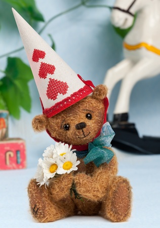 Cute little Teddy Bear with Daisys and Party Hut  on Playroom backgroundの写真素材