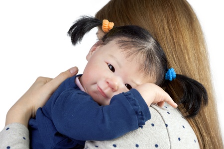 Rear view of mother with cute asian baby girl looking over shoulder の写真素材