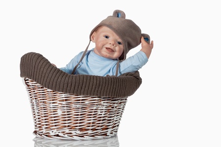 Sweet beautiful baby Doll Boy sitting in vintage basket の写真素材