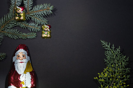 Two Chocolate Christmas toys - a bear on a christmas tree with a fir-tree cone on a black background...