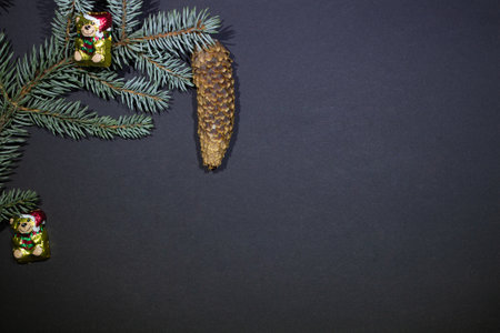 Christmas tree with a christmas tree cone with a toy - a chocolate bear - with empty space on a dark...