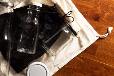 photo of reusable bags and jars for food storage - on a dark wooden background, top view