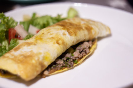 juicy ruddy pancake with tuna and salad on a white plate with a blurred background
