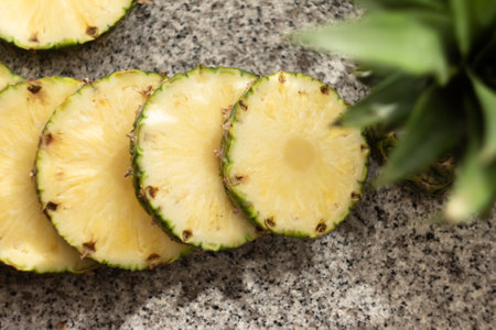 round pineapple slices on stone countertopの写真素材