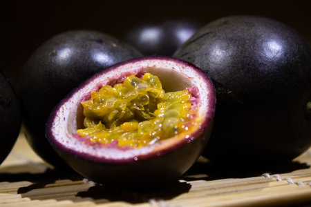 Close-up image of a sliced passion fruit showing its yellow flesh and seeds. The vibrant tropical...