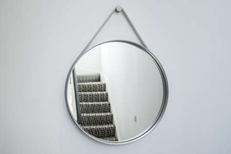 modern round designer mirror  in gray on white wallの写真素材