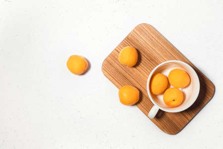 Apricot composition with wooden desk on white concrete background. Culinary web banner. Flatlay....