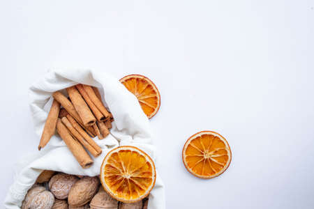 Eco bag with walnut, dry orange and cinnamon on white background . High quality photoの写真素材
