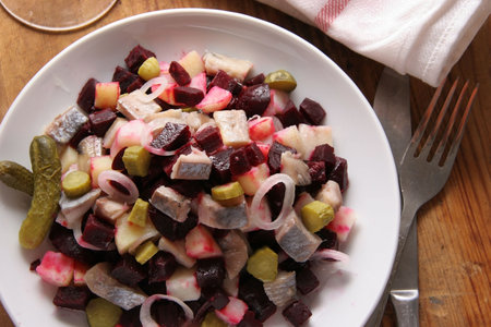 Salad made of herring, boiled potatoes, boiled beet, fresh onion and pickled cucumbers.の写真素材