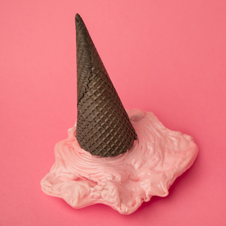 Overhead pink plastic ice cream on chocolate black cone on pasteの写真素材
