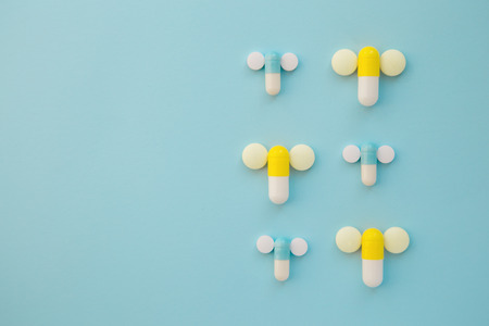 penis symbol made out of medical yellow and blue capsules and whの写真素材