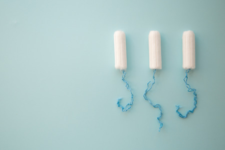 Menstrual tampon on a blue background top view. place for text.