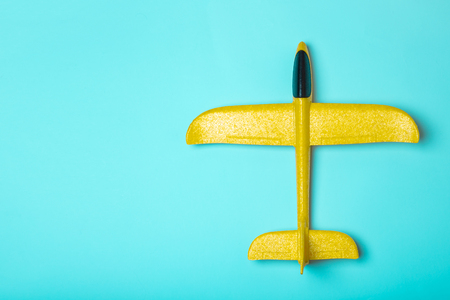 yellow model of passenger plane on blue backgroundの写真素材
