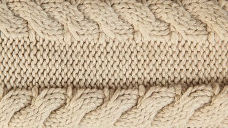 Close up of beige knitted winter sweater with pattern as textured material concept.の写真素材