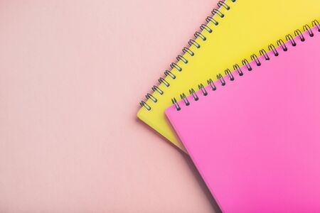 two Notepads pink and yellow on a pink background. Place for text. Note Sheetの写真素材