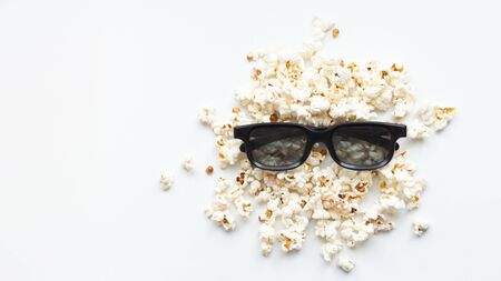 scattered popcorn and 3D glasses on white background. mock up. top view. cinema concept