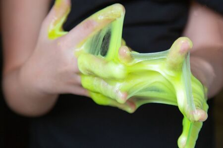 Kid Playing Handmade Toy Called Slime green color, Selective focus on Slime, Teenager having fun and being creative homemade slimeの写真素材