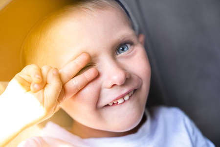portrait of caucasian cute blue-eyed boy smiling and laughing while sitting in the car on a sunny day. Happy children travel by carの写真素材