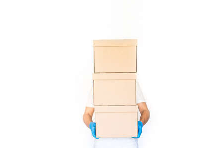 Delivery man holding cardboard boxes in blue rubber gloves with copy space. Fast and free Delivery...
