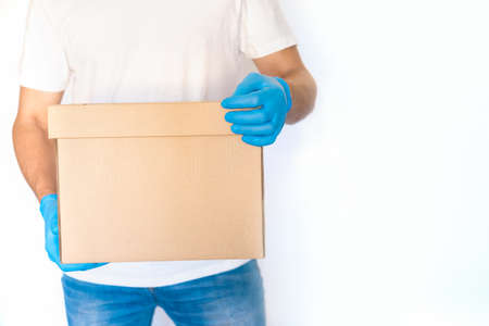 Delivery man holding cardboard boxes in blue rubber gloves with copy space. Fast and free Delivery...