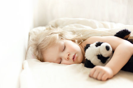 Closeup of little girl sleeping hugging panda teddy bearの写真素材