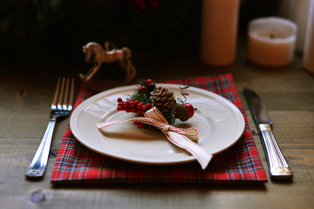 Christmas place setting and decorations on wooden tableの写真素材