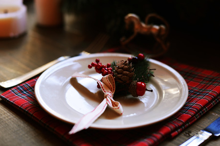 Christmas place setting and decorations on wooden tableの写真素材