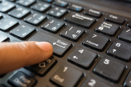 close up women finger point or click on enter button on the keyboardの写真素材