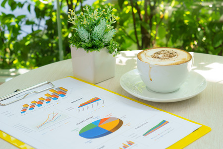 business analysis information document with latte art coffee and small plant on the table near the...