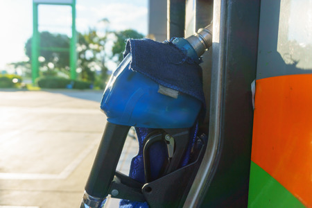 petrol pump nozzle for fill fuel at gas station in sunny dayの写真素材