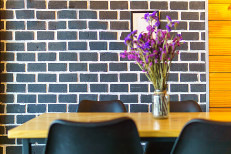 purple flower bouquet in on the wooden table with blurred brick wall background.の写真素材