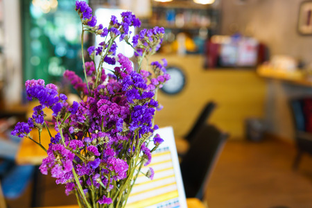 purple flower bouquet in on the wooden table with blurred brick wall background.の写真素材