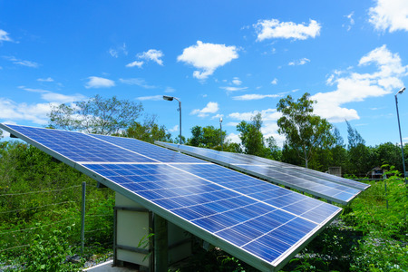 solar cell generating electricity and installed in the forest with blue sky and cloud and green tree background. electricity, ecology power concept.の写真素材