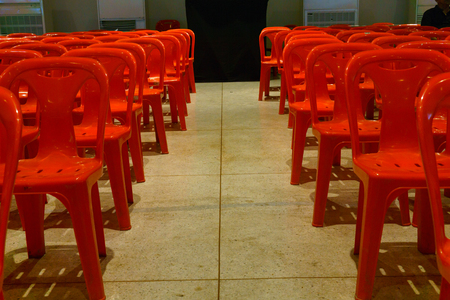 Row of well organized red plastic chair in the plearnary hall for biggest event.の写真素材