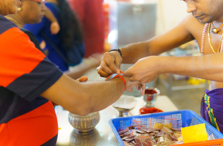 Singapore, October 21, 2017.Hindu priests are tying their wrists with white thread for prosperity.のeditorial素材