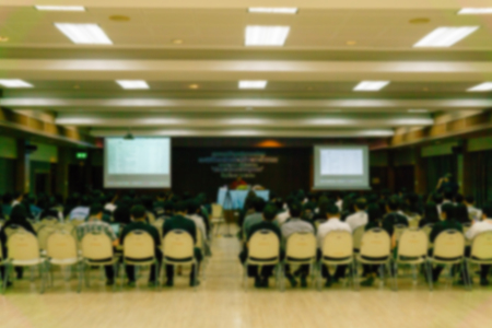 BLURRED image of seminar room with full of people listening to speaker presentation.  or business...