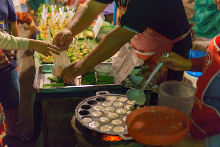 close up,selective focus. hand of thai dessert seller give the bag to customer on the walking street.の写真素材
