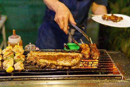 selective focus, close up of pork steak or barbecue on the charcoal stove for grill.の写真素材