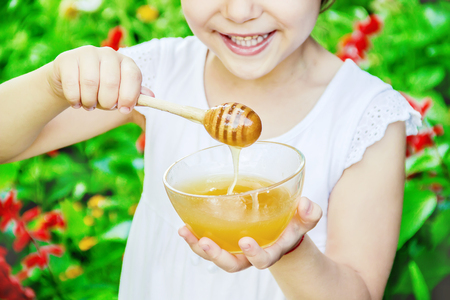 The child eats honey. Selective focus. nature.の写真素材
