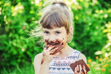 A sweet-toothed child eats chocolate. Selective focus. nature.の写真素材