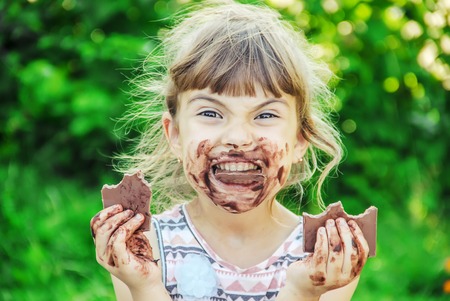 A sweet-toothed child eats chocolate. Selective focus. nature.の写真素材