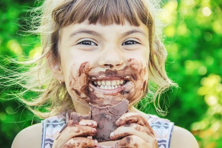 A sweet-toothed child eats chocolate. Selective focus. nature.の写真素材